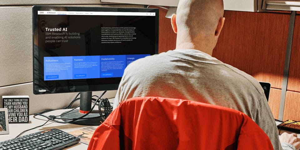A man working on a computer in a cubicle