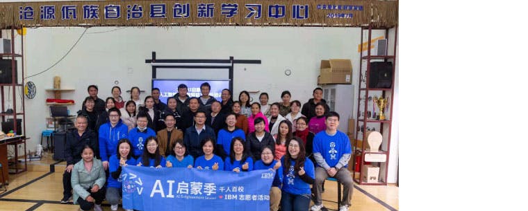 A group picture. The front row is holding a banner for IBM volunteers and the AI Enlightment season