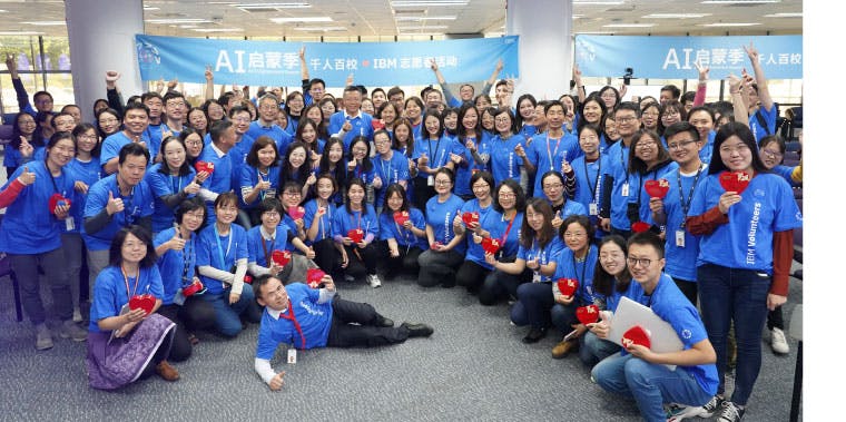 A large group of IBM volunteers in China under banner for the AI Enlightenment Season