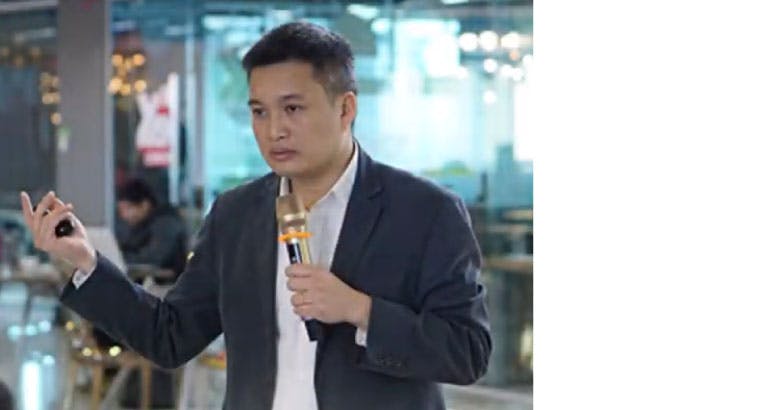 Le Nhan Tam speaking with a microphone