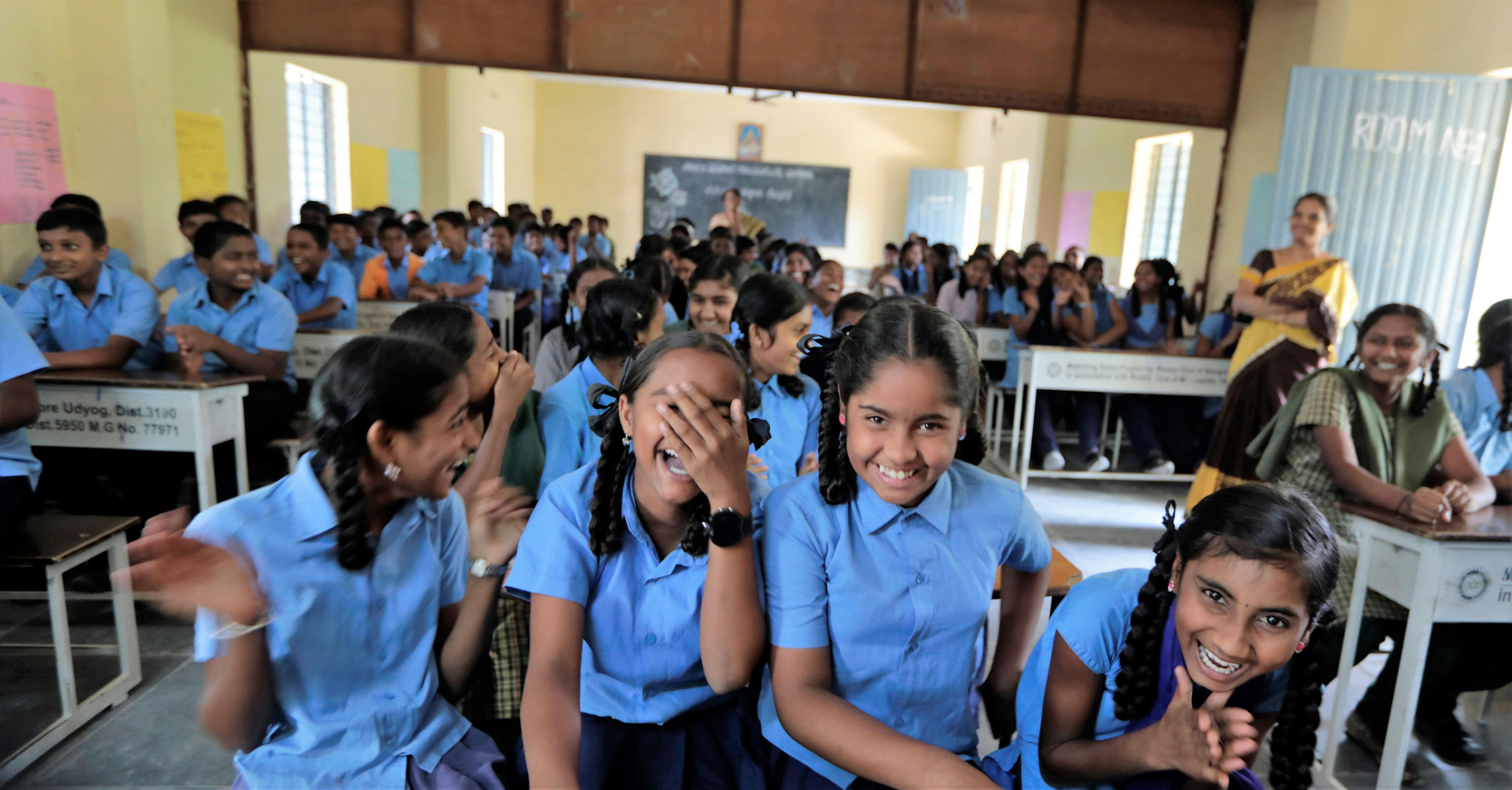 Young girls smiling and laughing in a classroom in India