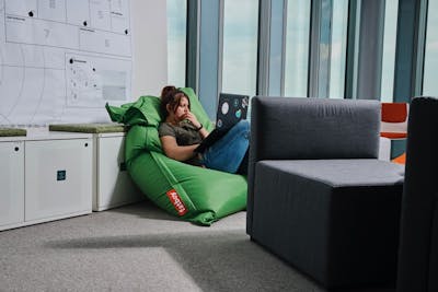 Girl on a bean bag chair working on a laptop