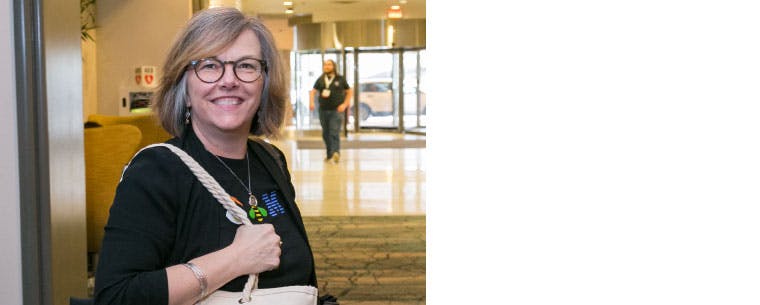A picture of Heather Ricciuto smiling, wearing glasses and a t-shirt that says IBM