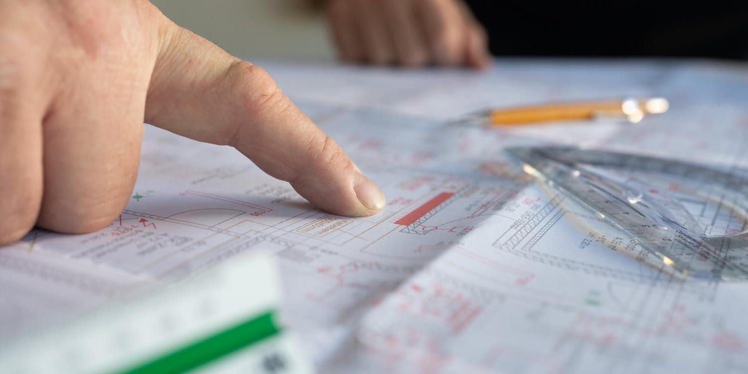 Finger und Lineal auf Projektplan Finger und Lineal auf Projektplan