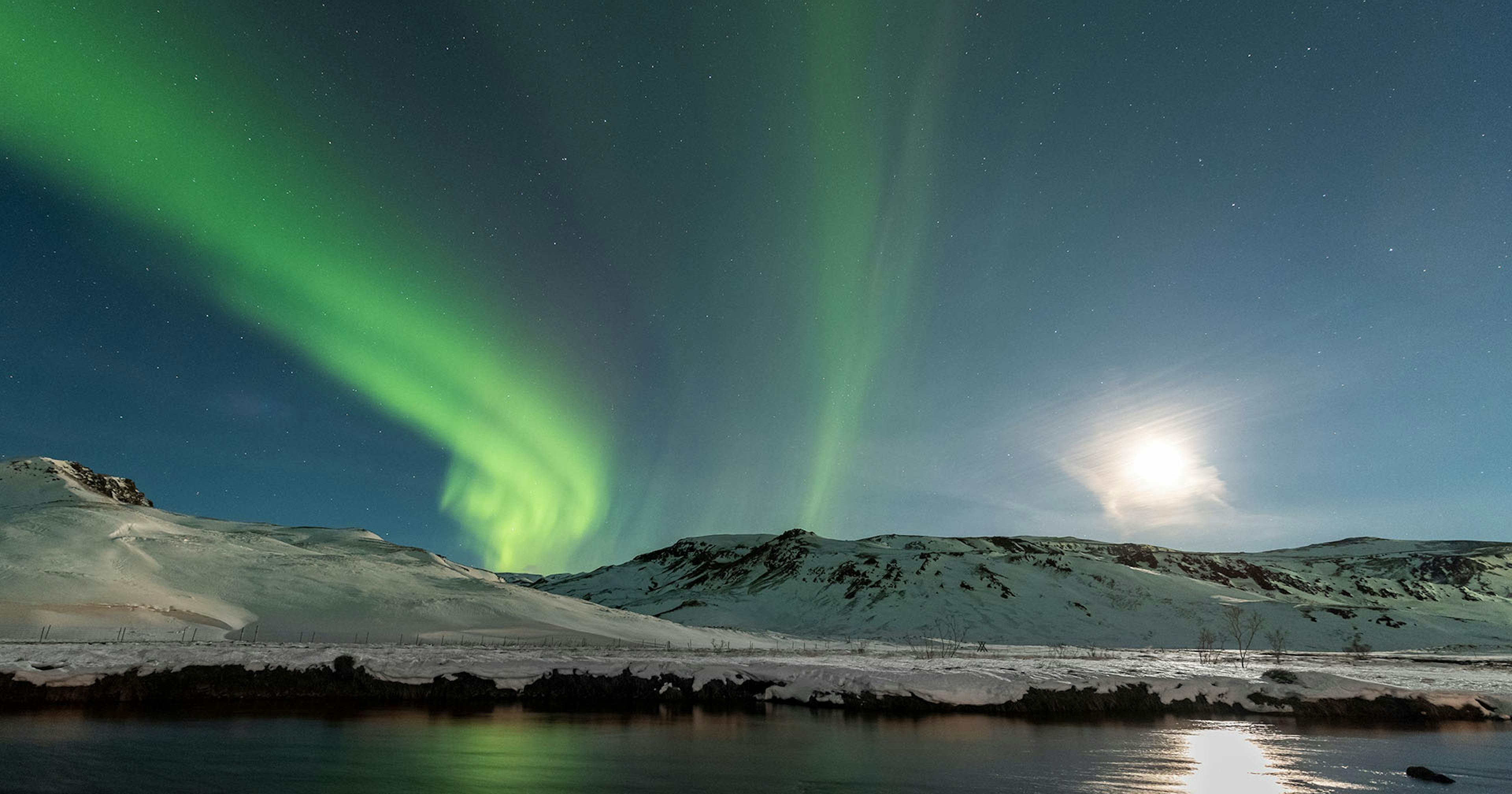 Full Moon over Reykjadalur with Northern Lights. Credit: Gísli Már Árnason