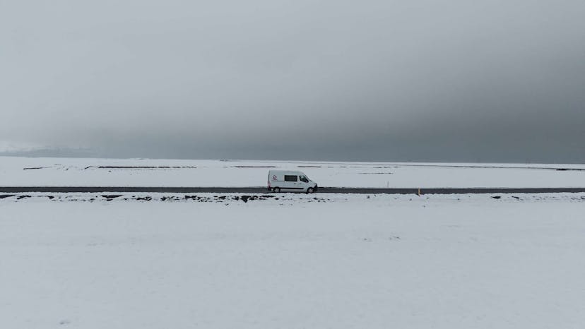 Iceland Campervan driving on the road surrounded by snow