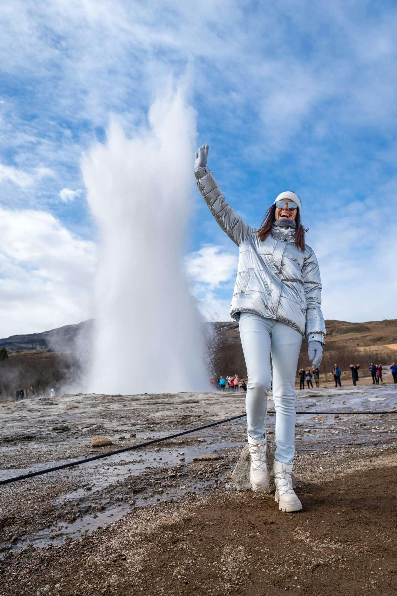 Woman posing by Geysir geothermal area in Iceland
