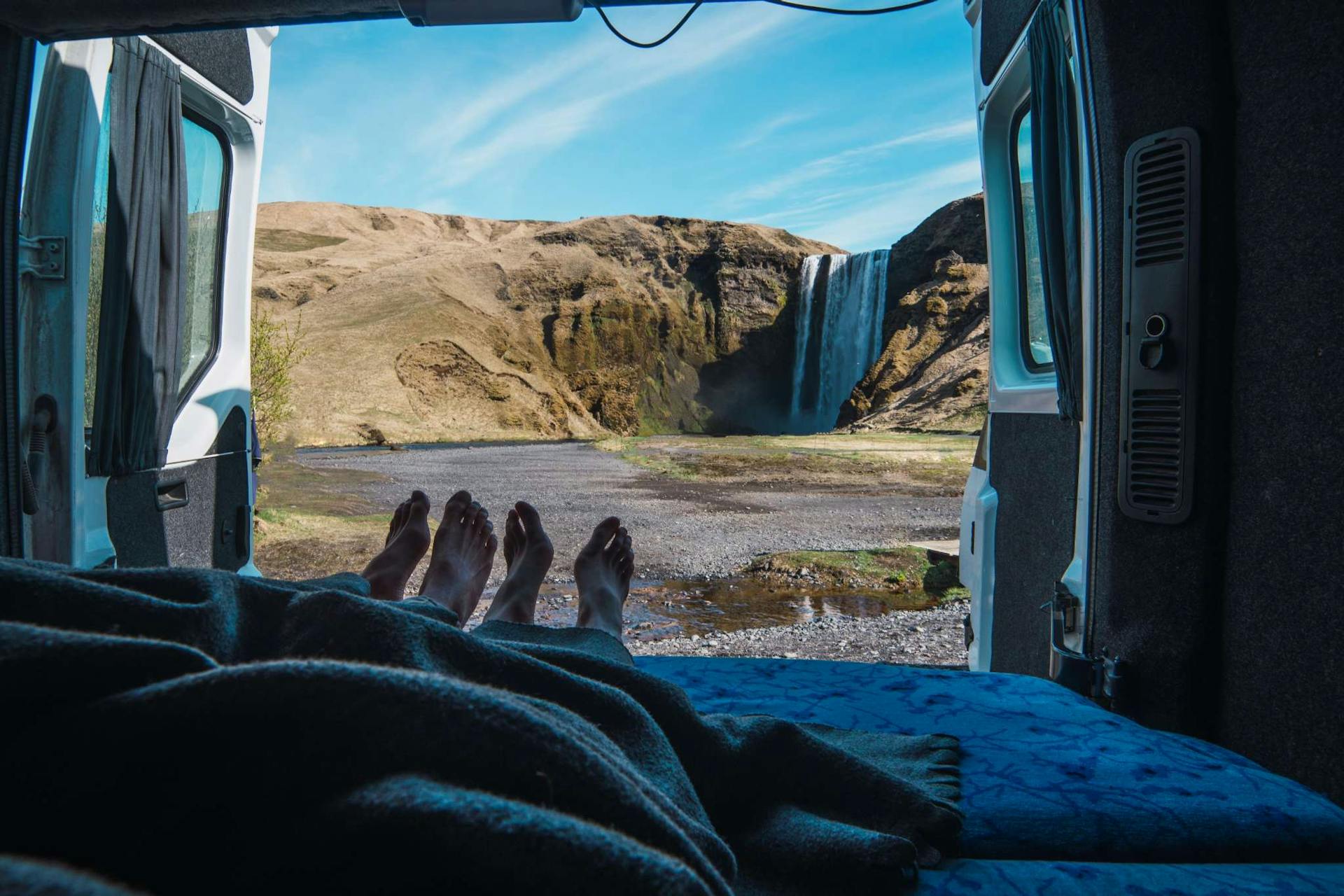 Couple in campervan by Skogafoss waterfall
