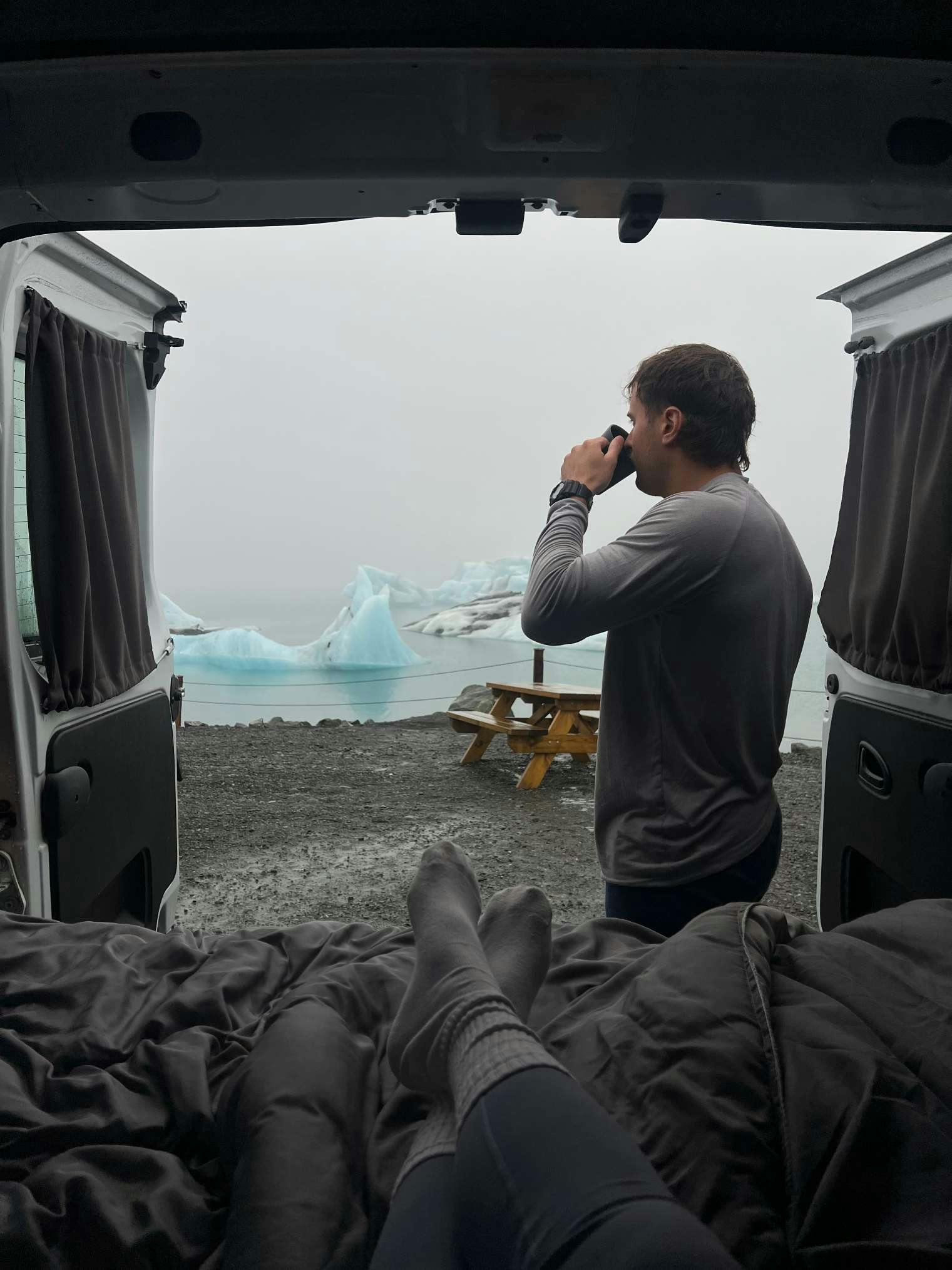 Man drinking coffee in campervan at Glacier lagoon Iceland