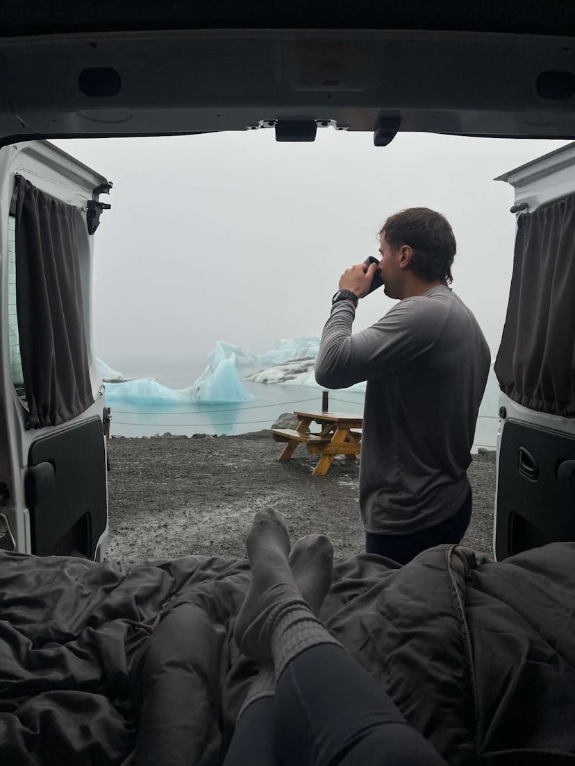 Man drinking coffee in campervan at Glacier Lagoon Iceland