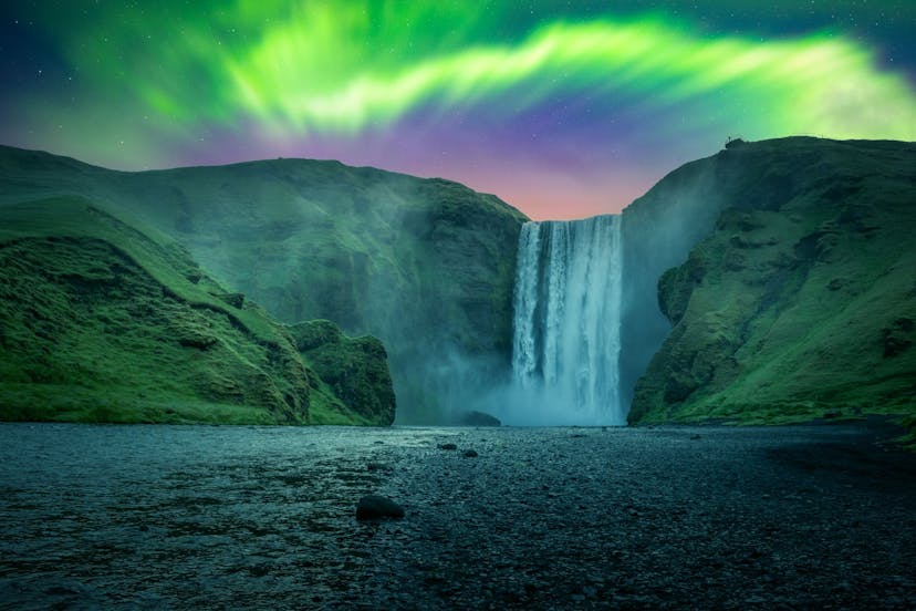 Skogafoss waterfall surrounded by northern lights