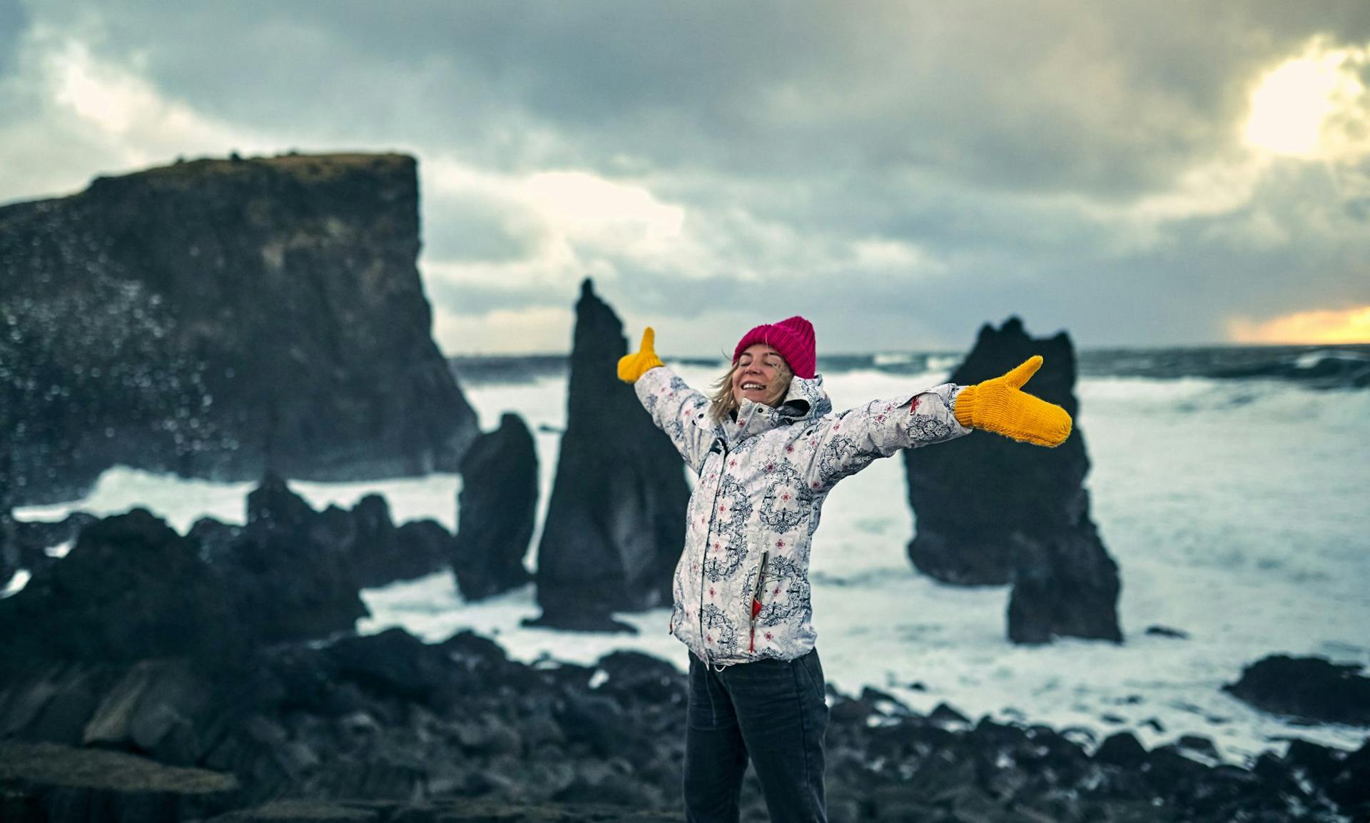 Woman smiling by sea stacks in Iceland