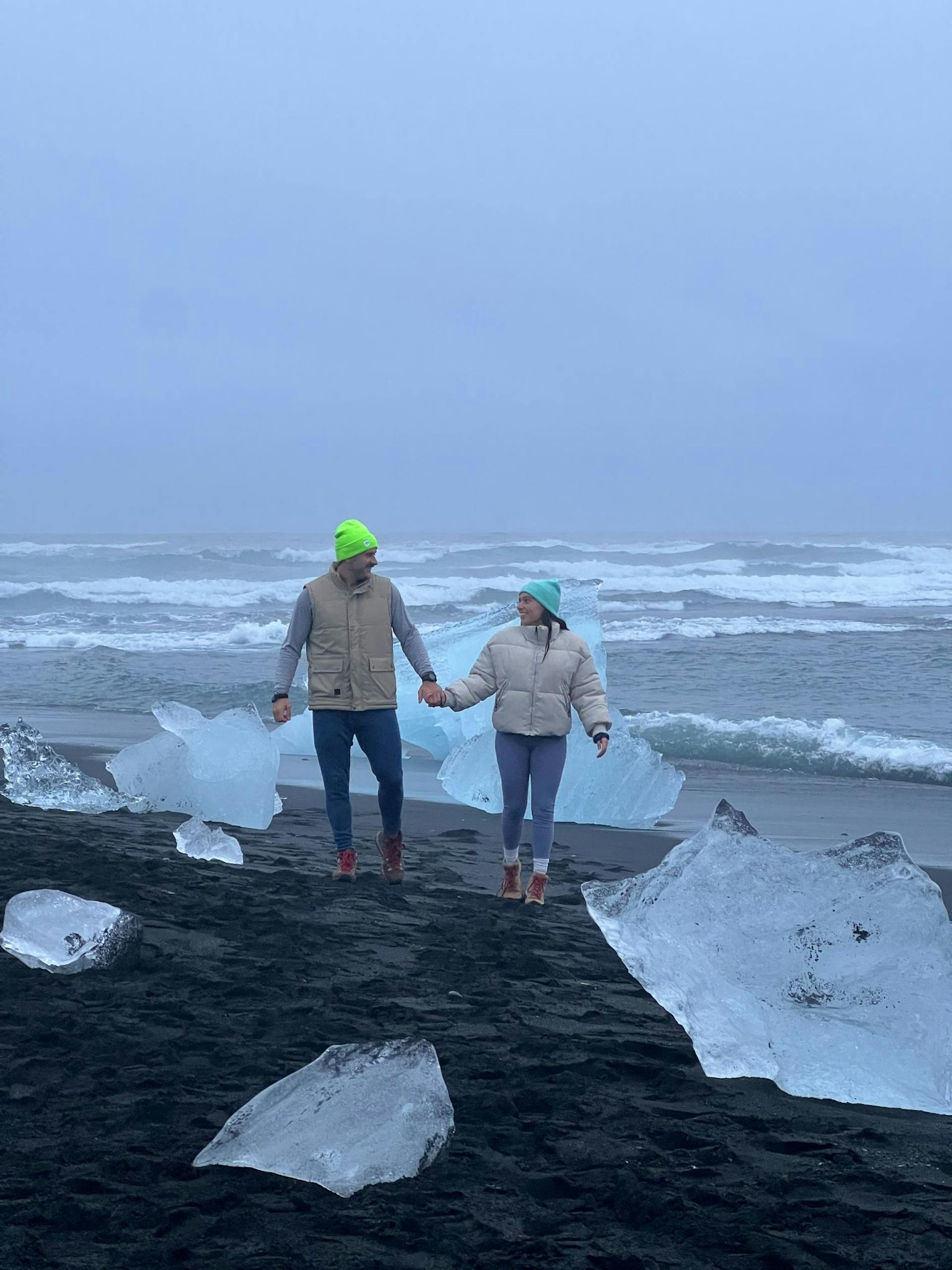Couple holding hands at Diamond beach, Iceland