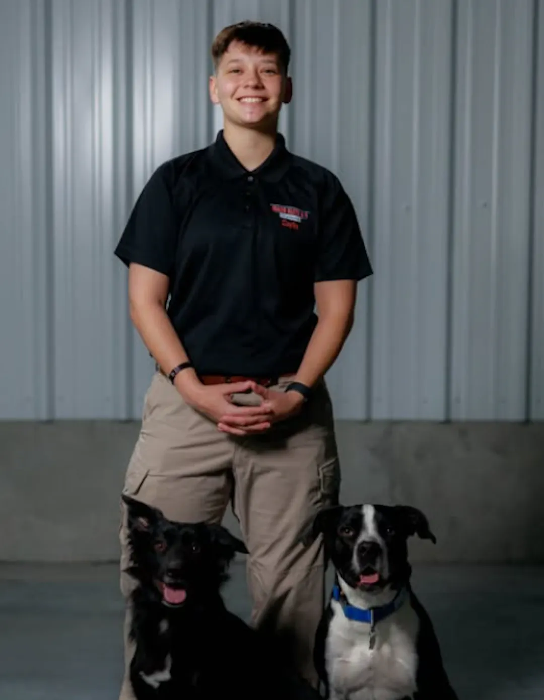 Elite dog trainer smiling with two dogs.