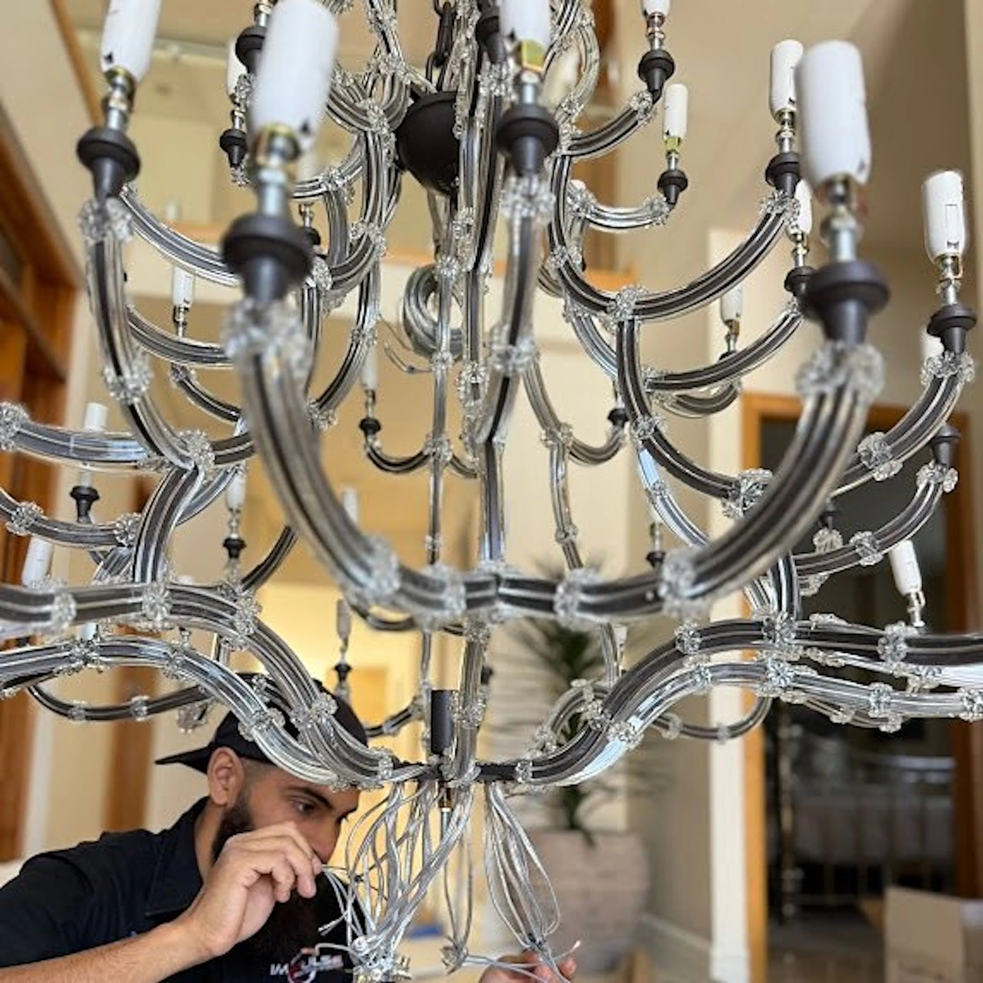 An Impulse Electrical Enterprise electrician wiring a chandelier on the job