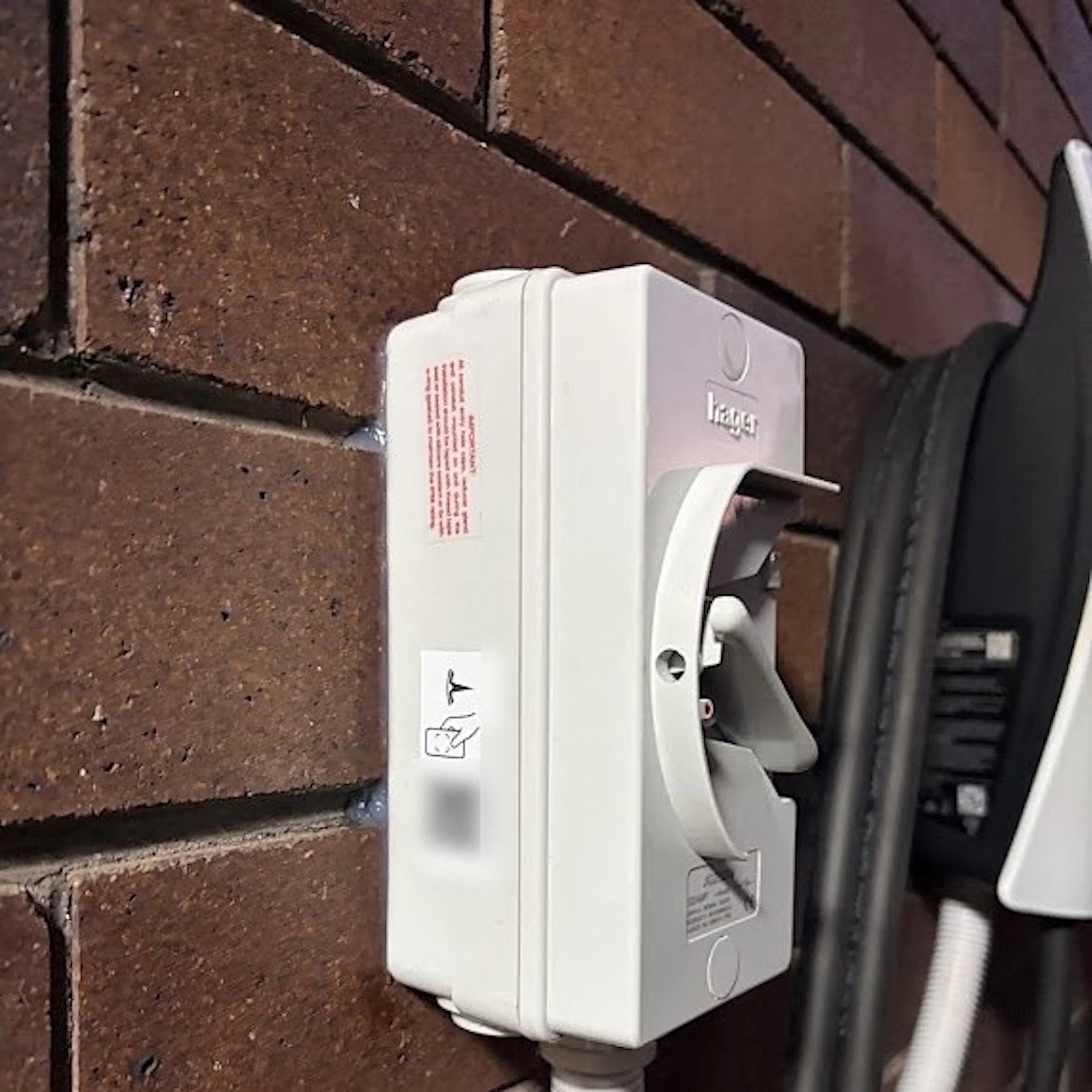 Isolator enclosure beside a home EV charger, by Impulse Electrical Enterprise