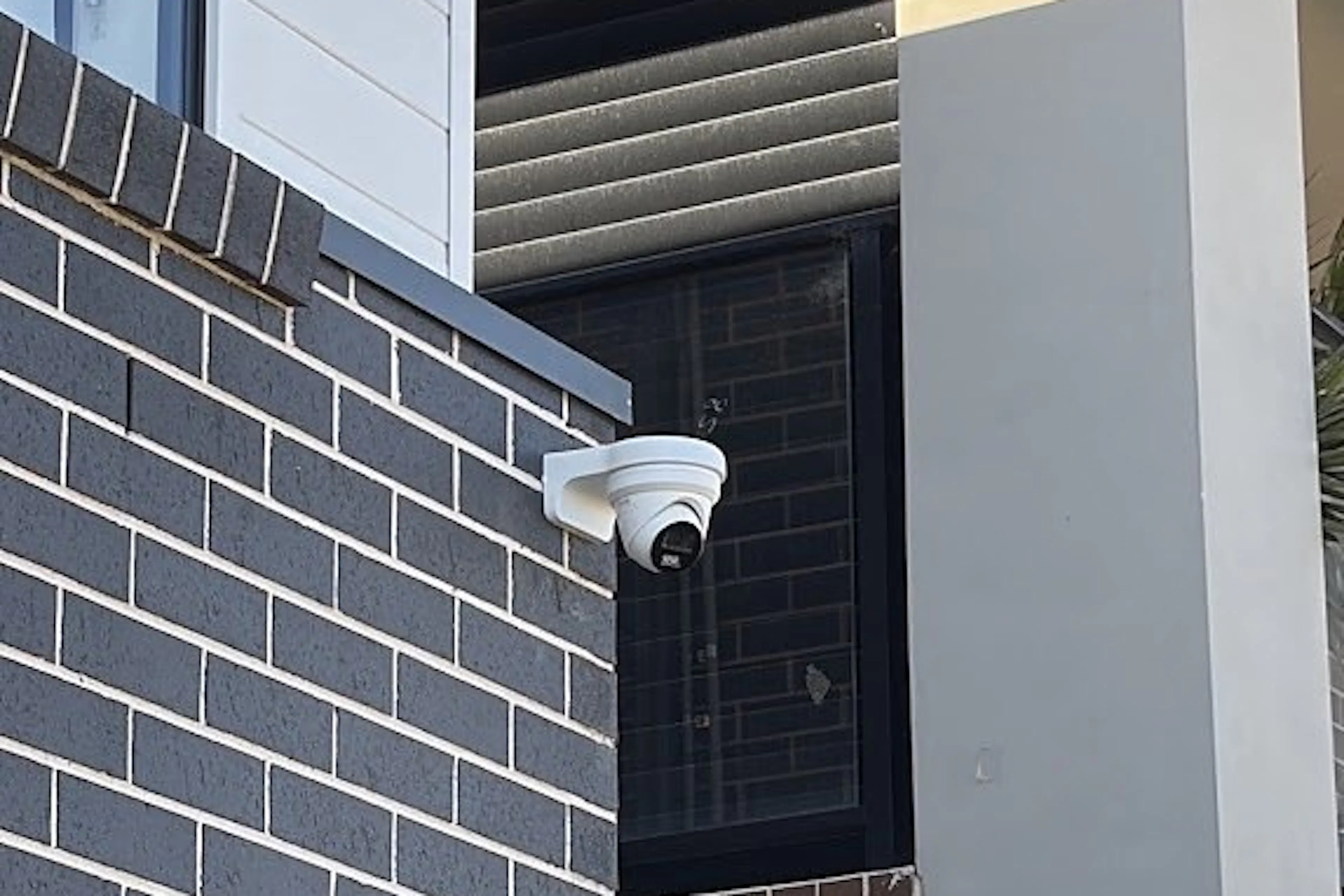 Bullet CCTV camera installed on a wall as part of a four-camera security system