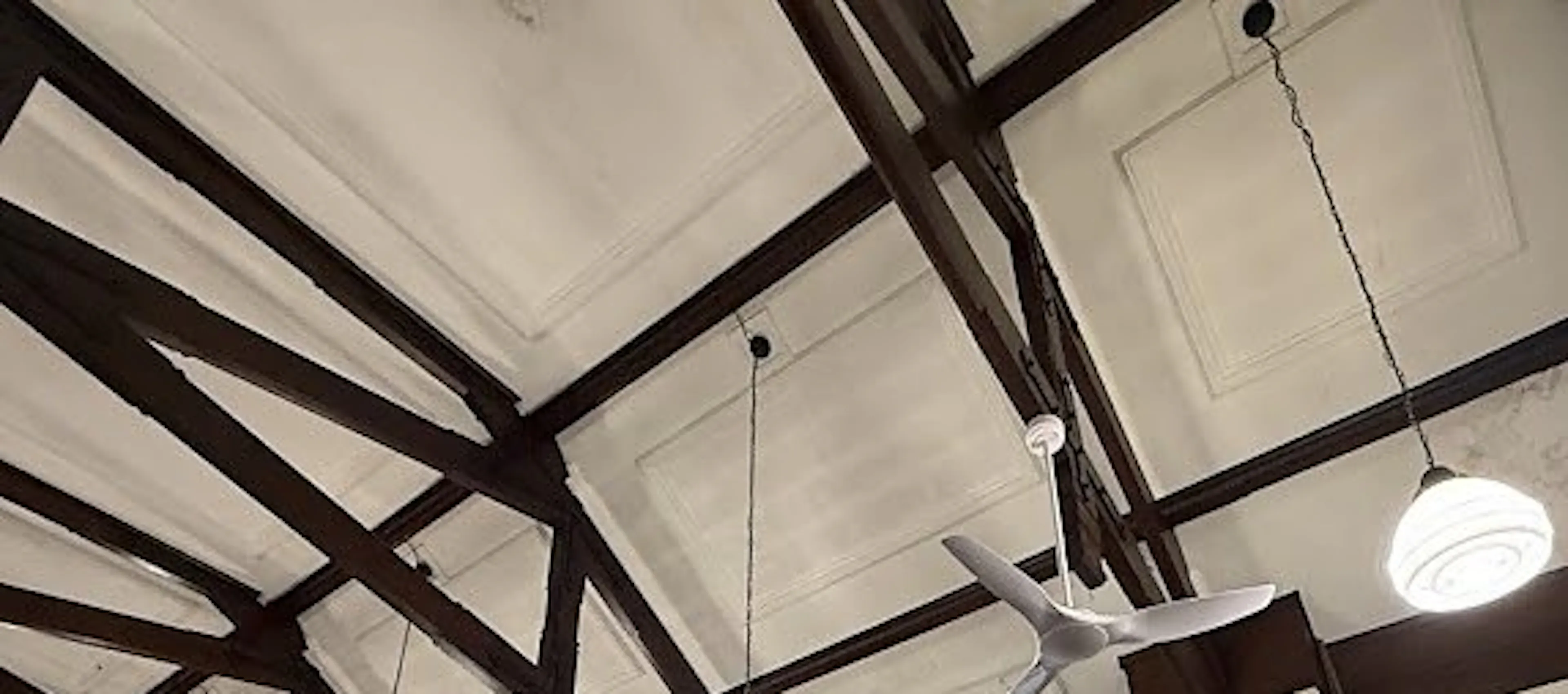 New ceiling fans and pendant lights under the roof trusses of an Ashfield church hall, by Impulse Electrical Enterprise