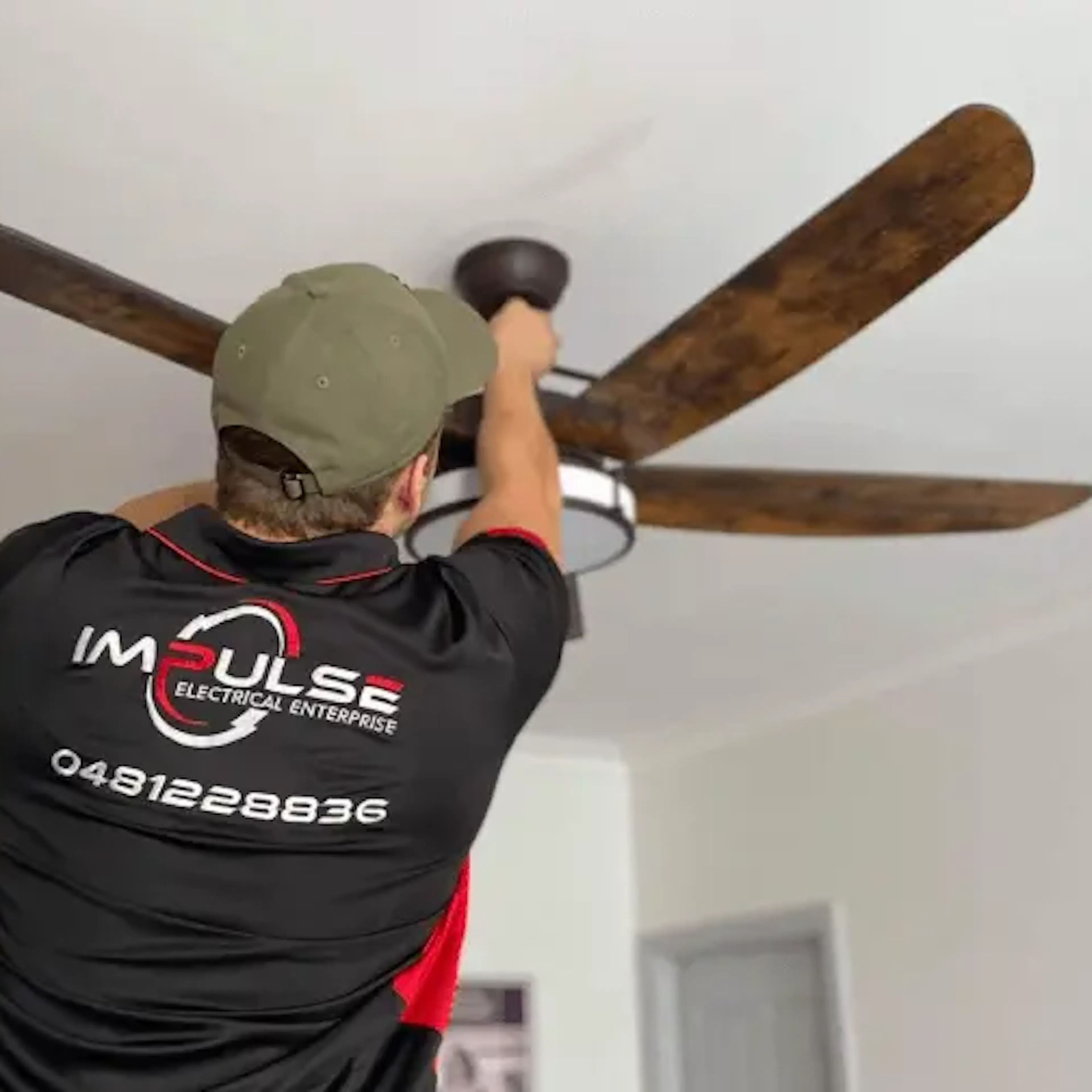 Licensed electrician installing a ceiling fan in a Sydney home