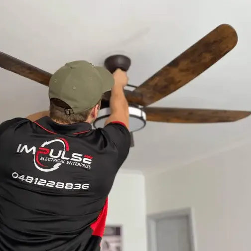 Licensed electrician installing a ceiling fan in a Sydney home