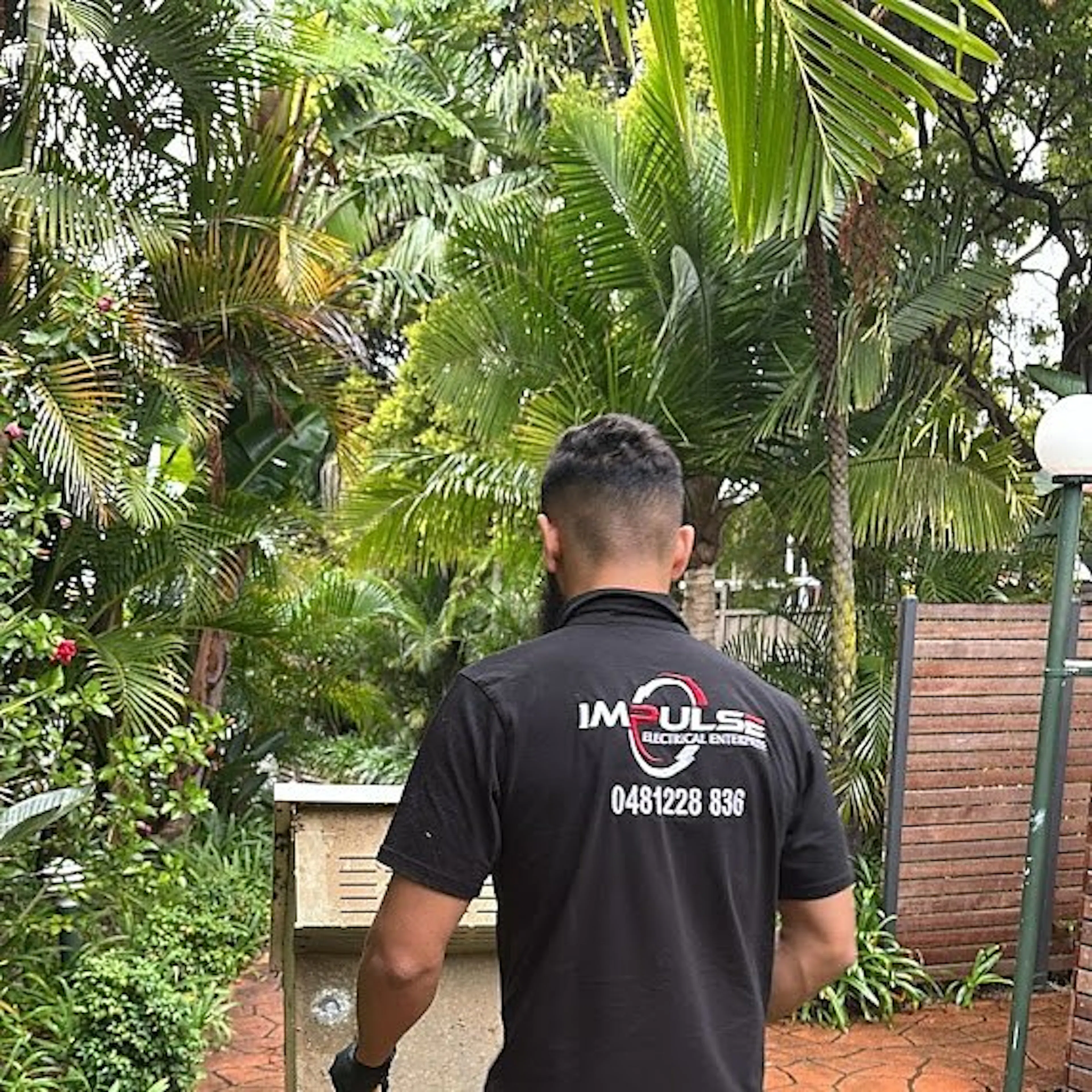 An Impulse Electrical Enterprise electrician in the branded work shirt