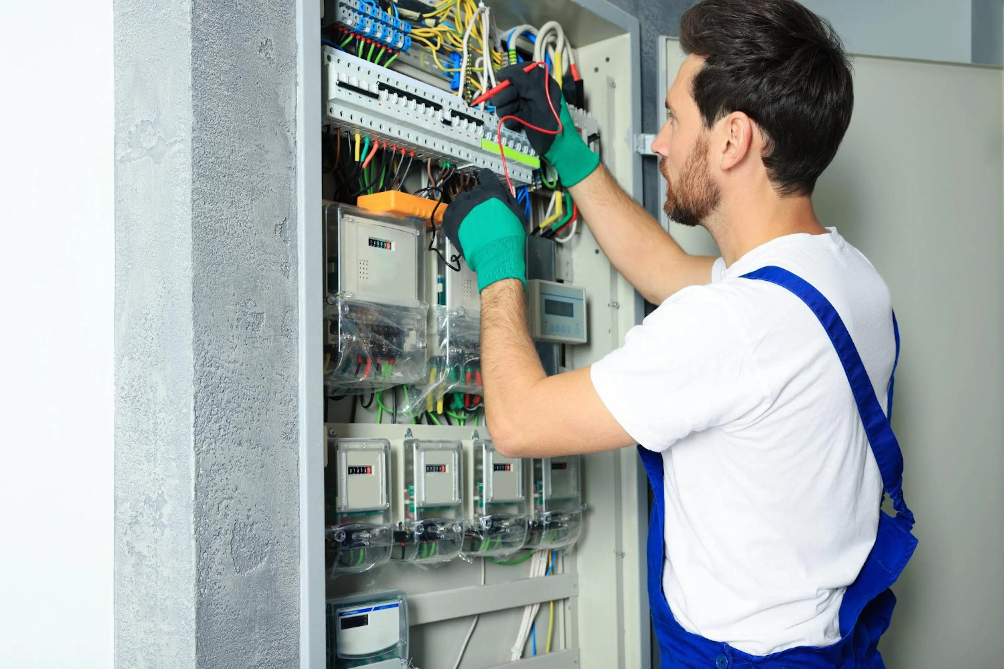 Electrician working inside an open switchboard