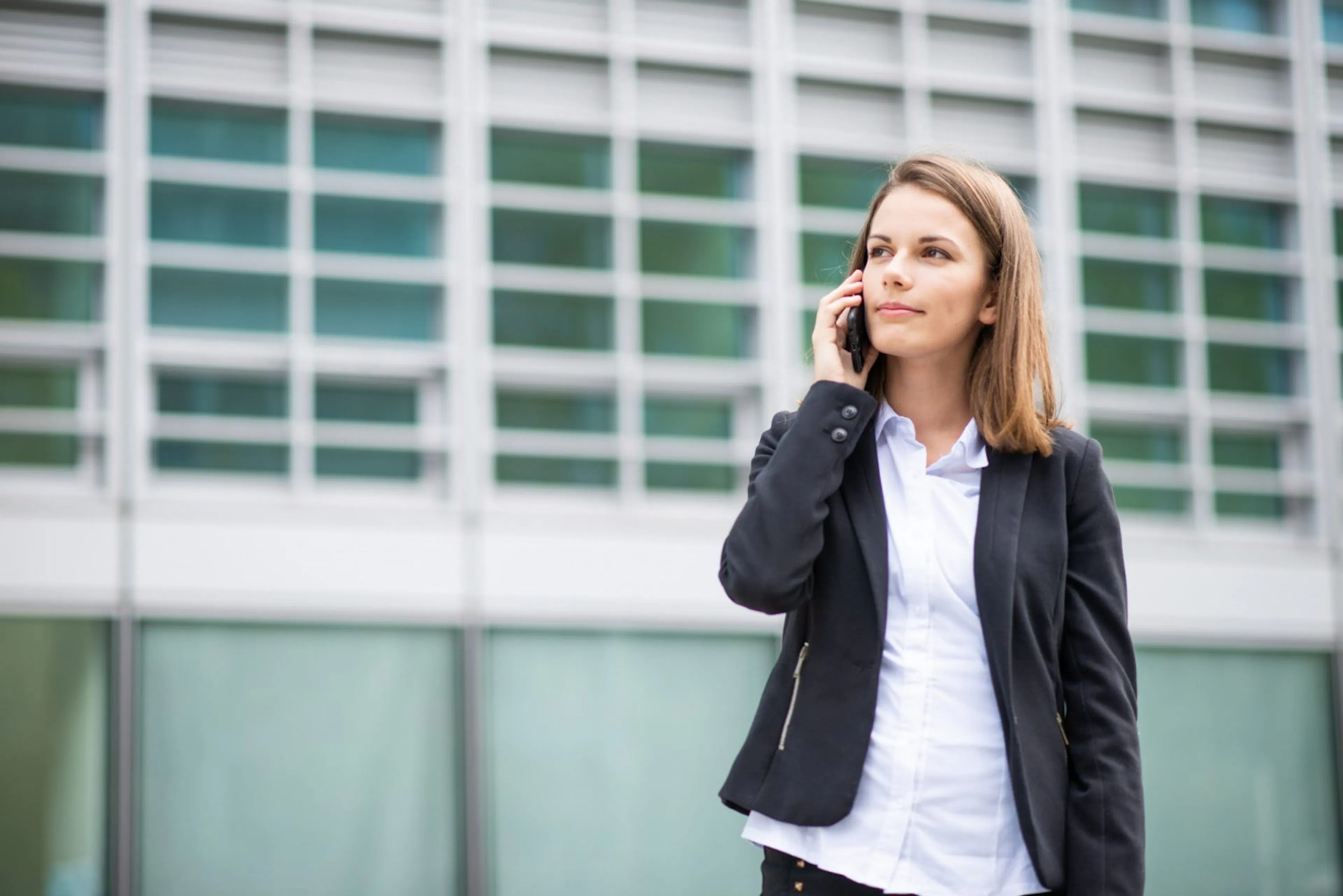 Woman making a phone call outside an office building