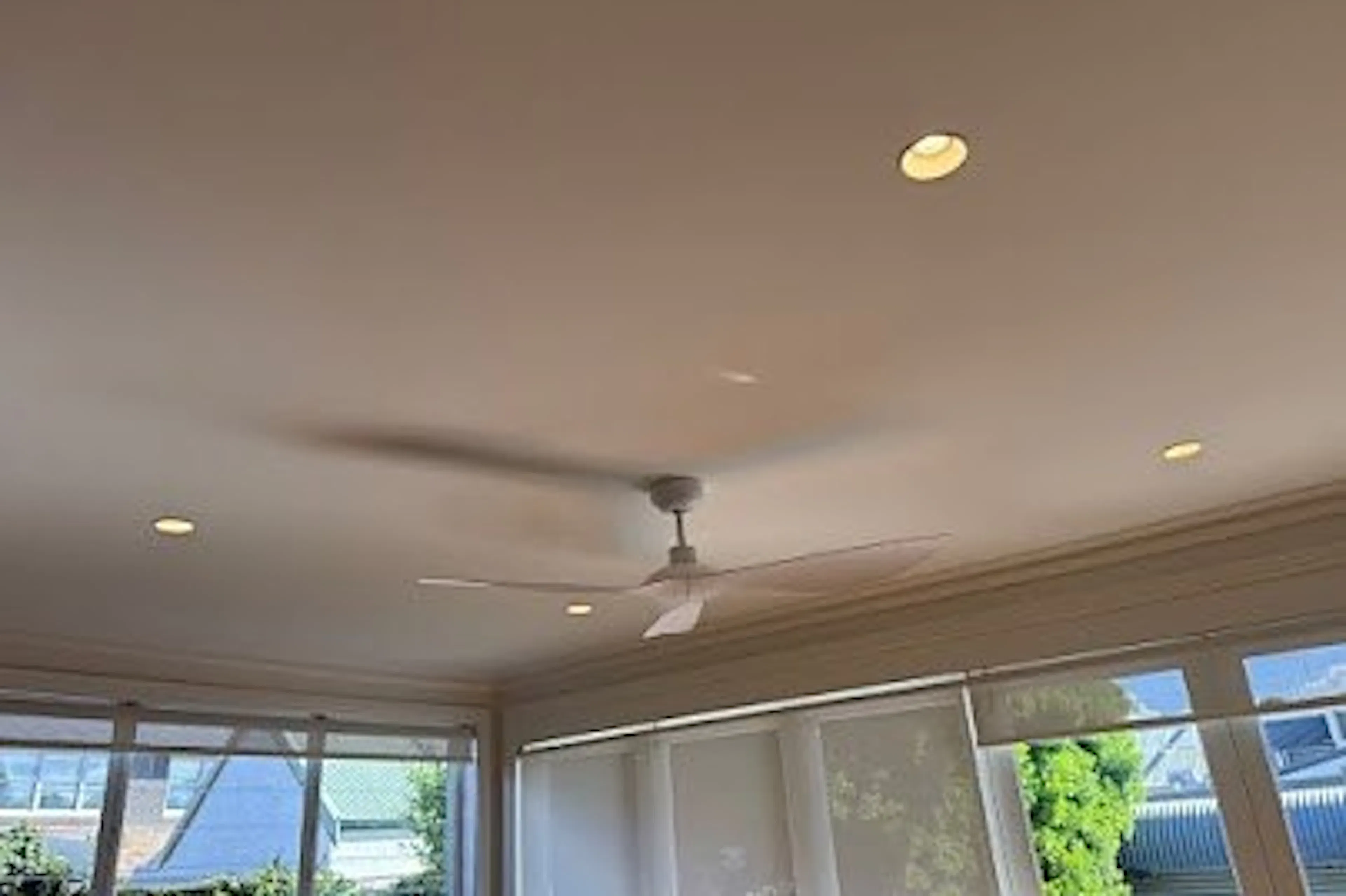 White DC ceiling fan installed in a living room with downlights