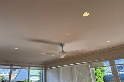 White DC ceiling fan installed in a living room with downlights