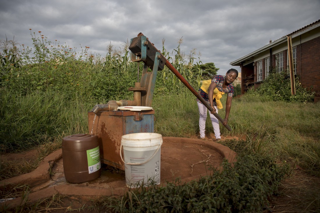 Abigail draws water from a borehole near her home in Hatcliffe, Harare, Zimbabwe. The borehole malfunctions so Abigail often has to work twice as hard in order to draw water from it.