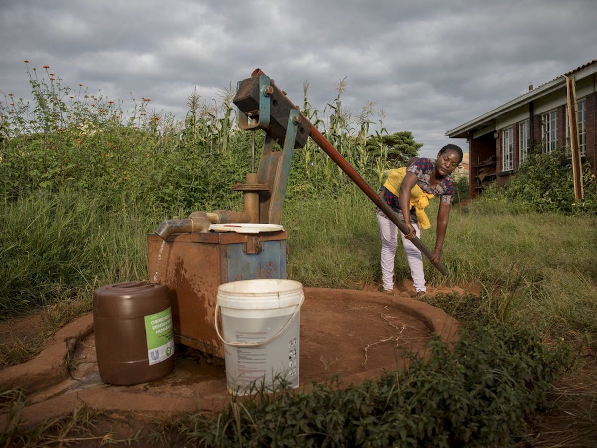 Abigail draws water from a borehole near her home in Hatcliffe, Harare, Zimbabwe. The borehole malfunctions so Abigail often has to work twice as hard in order to draw water from it.