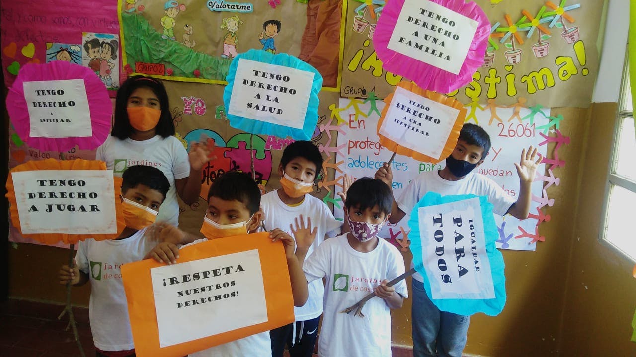 Niños en uno de los centros instalados durante las cosechas de tabaco. Sostienen carteles que han confeccionado con frases como "Tengo derecho a jugar" y "¡Respeta nuestros derechos!".