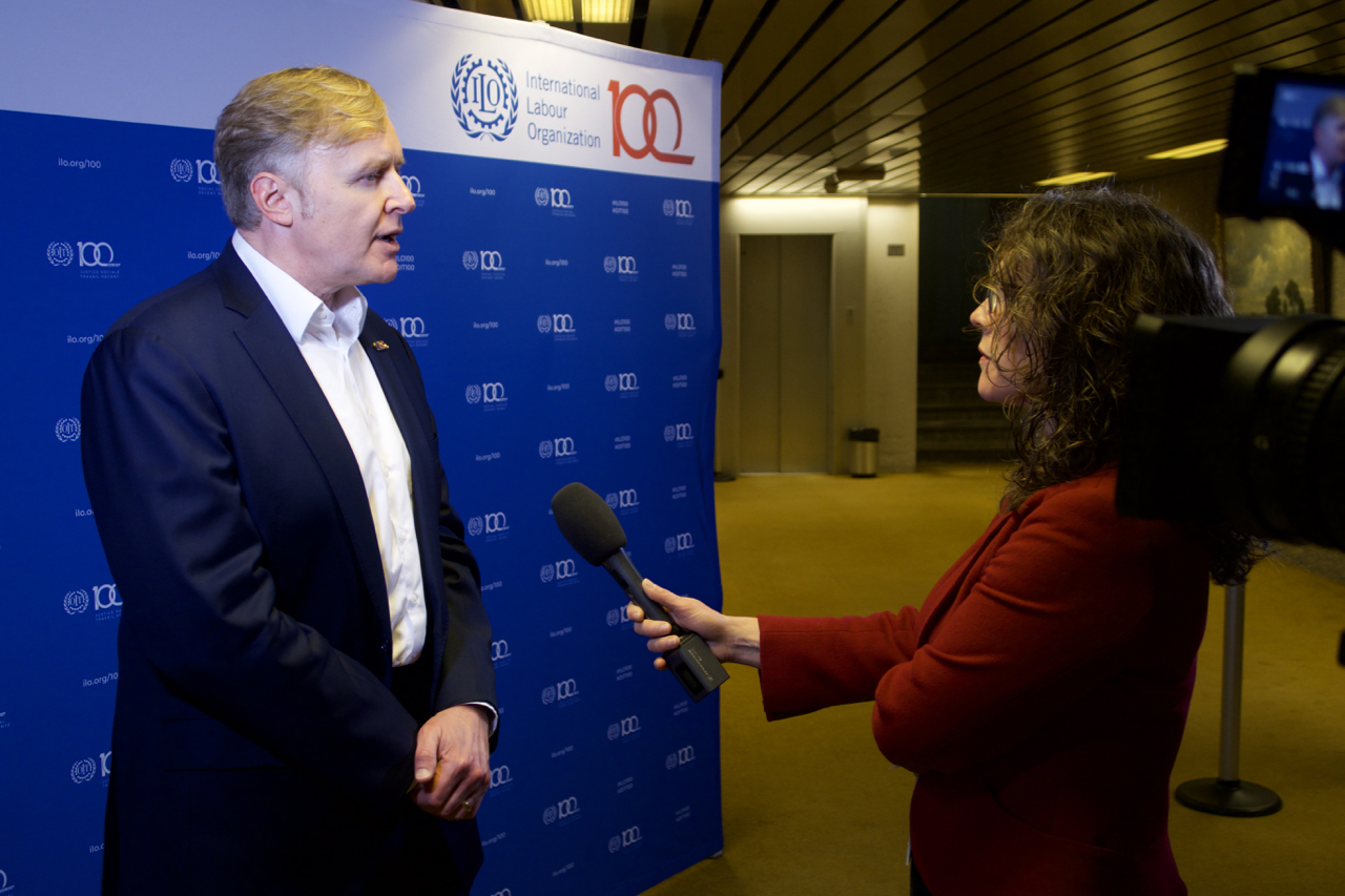 LinkedIn Co-Founder Allen Blue at ILO Headquarters in Geneva gives an interview to a women with a microphone.