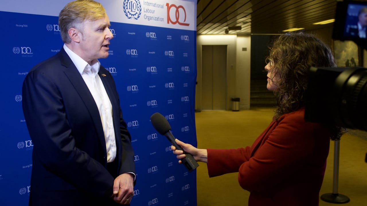 LinkedIn Co-Founder Allen Blue at ILO Headquarters in Geneva gives an interview to a women with a microphone.