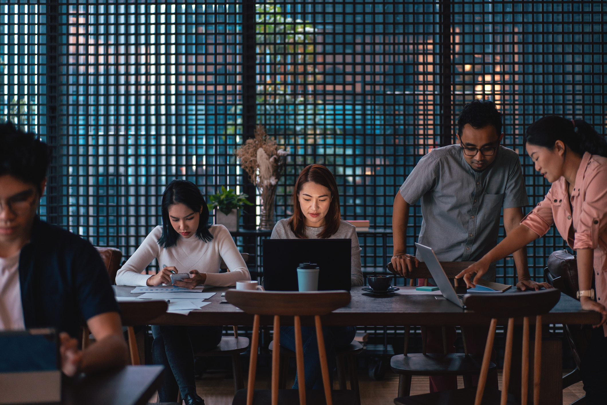 A small multiracial team working at a table together on problem solving