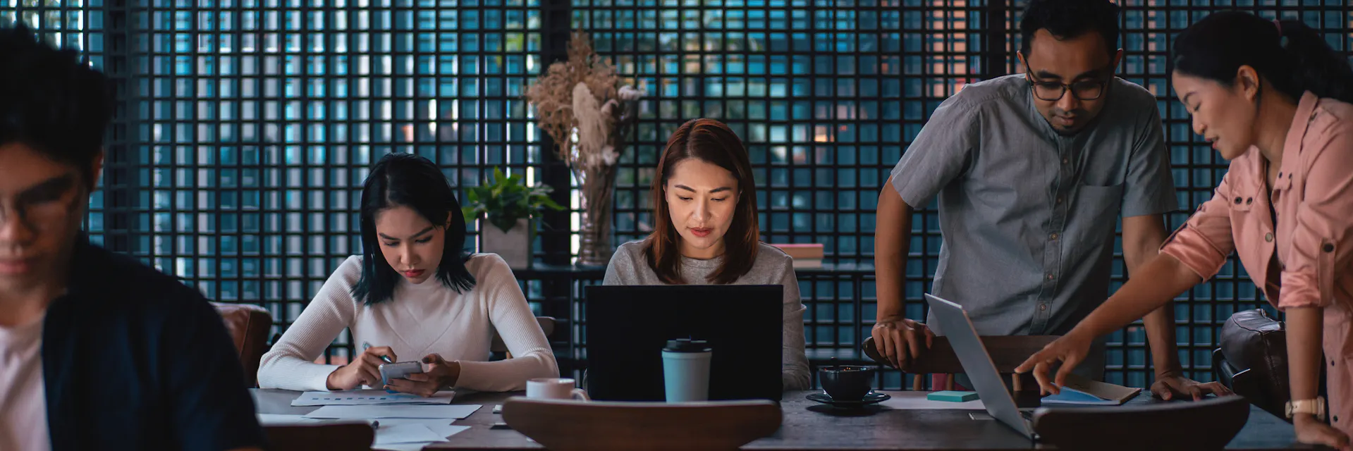 A small multiracial team working at a table together on problem solving