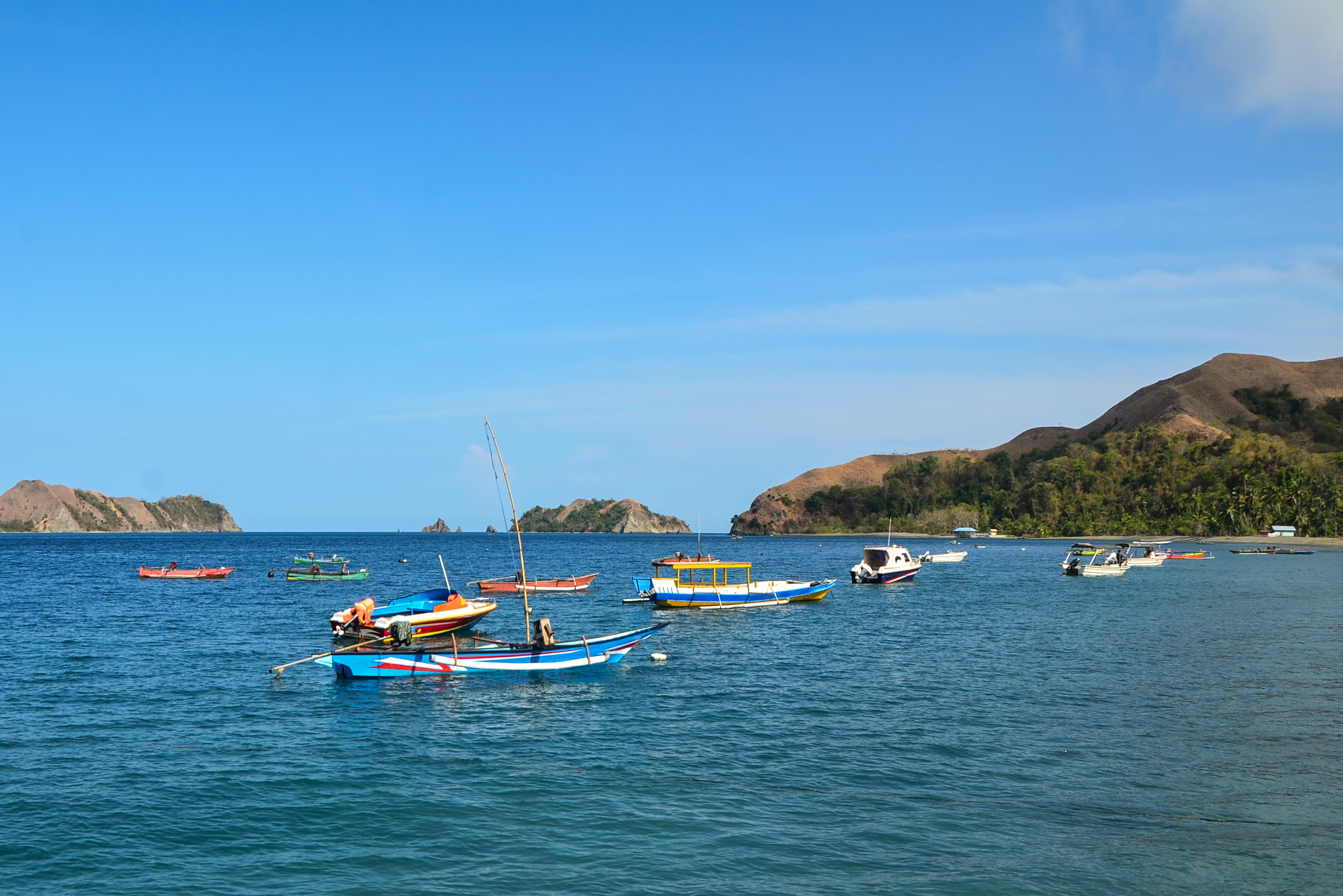 Des petits bateaux à moteur, colorés, au large de Banggai, sur l’île de Dua (Sulawesi central, Indonésie)