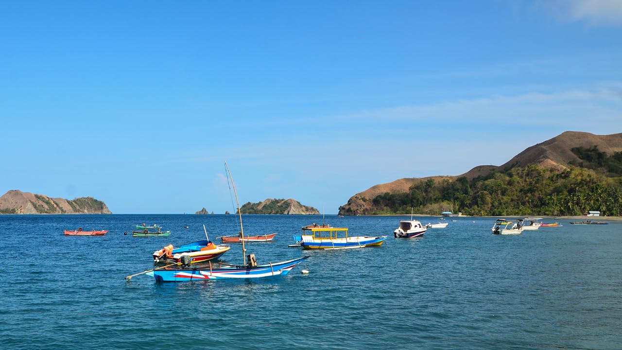 Des petits bateaux à moteur, colorés, au large de Banggai, sur l’île de Dua (Sulawesi central, Indonésie)