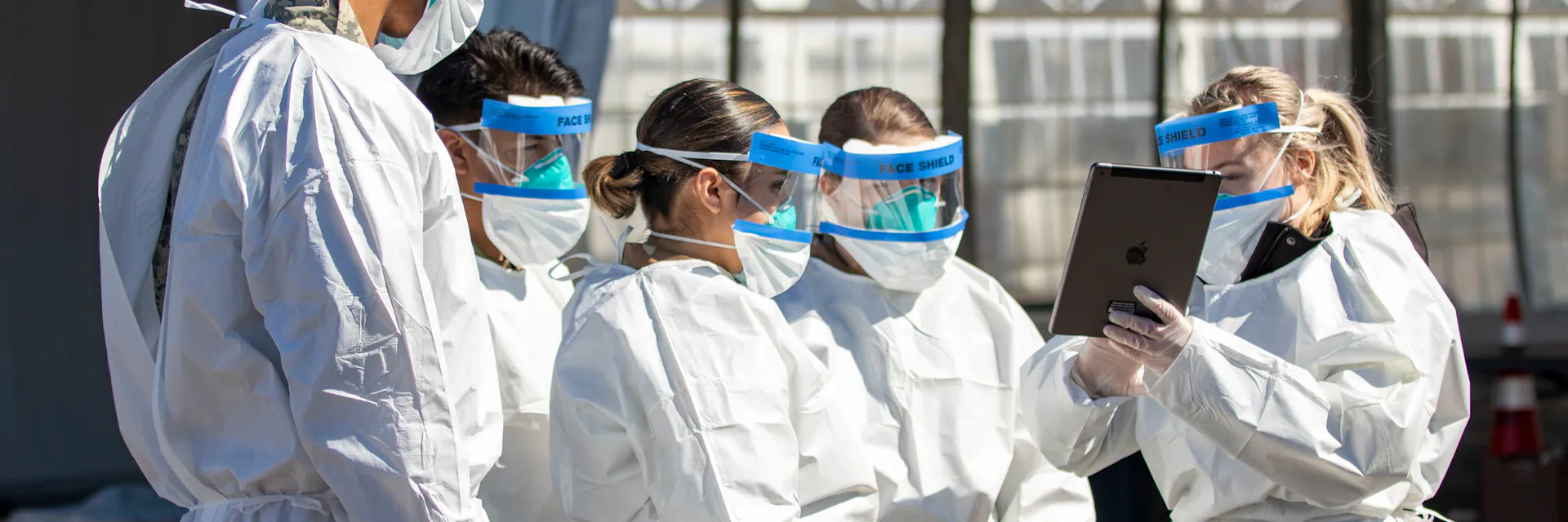 Un employé du ministère de la Santé forme des soldats de la Garde nationale de l'armée de New York pour enregistrer les personnes dans un centre de test mobile COVID-19 à Glenn Island Park, New Rochelle, le 14 mars 2020. Ils portent tous des équipements de protection individuelle.