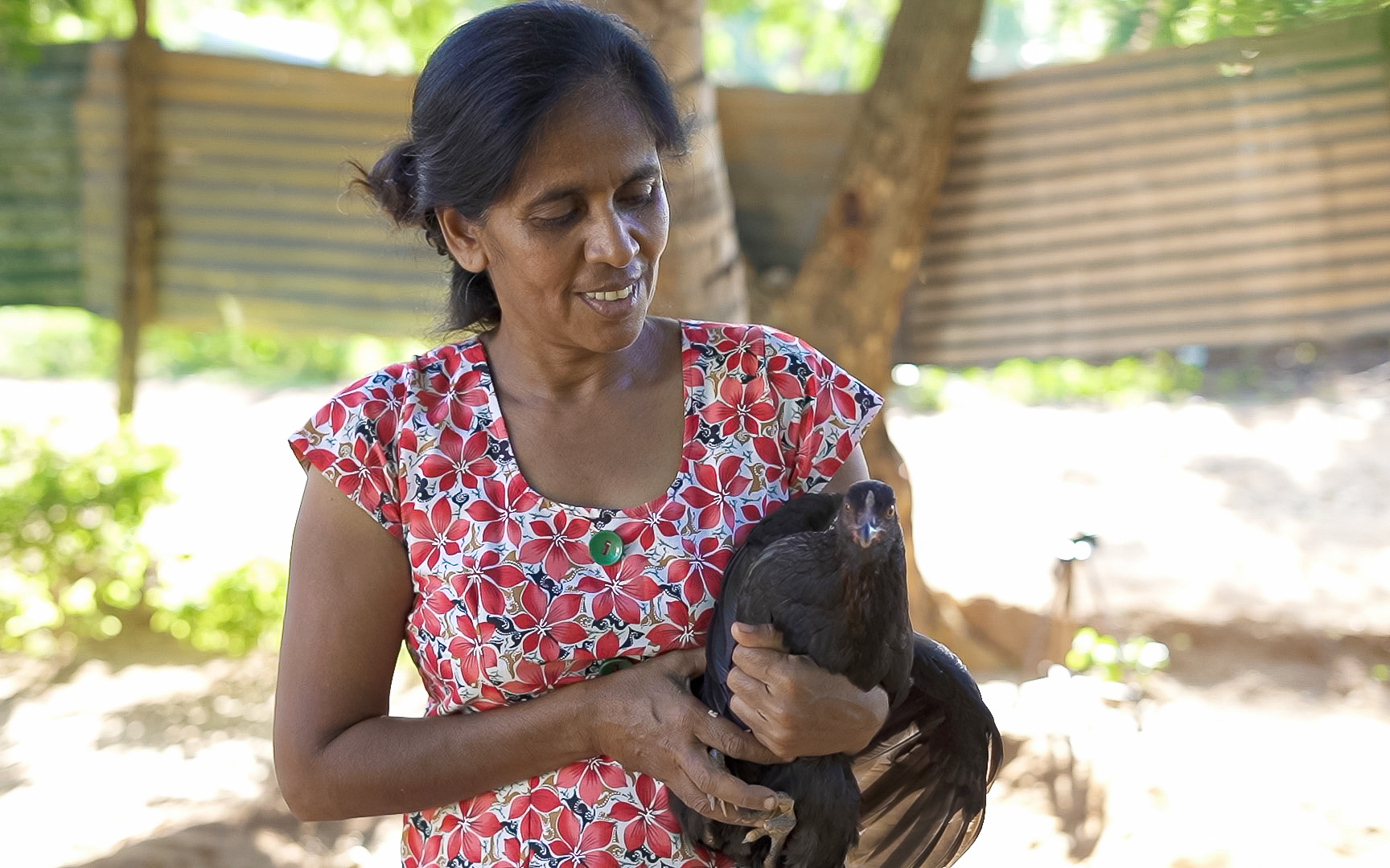 Veronica holds a chicken and smiles.