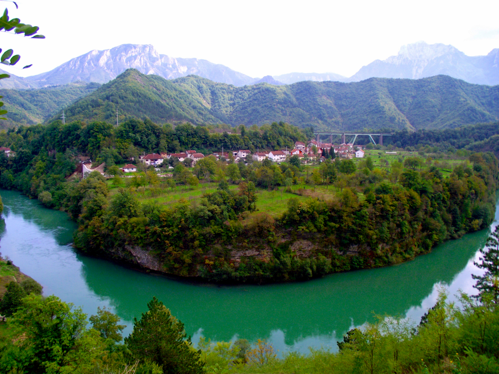 The town of Jasablanca with the Neretva river in the foreground and mountains in the background.