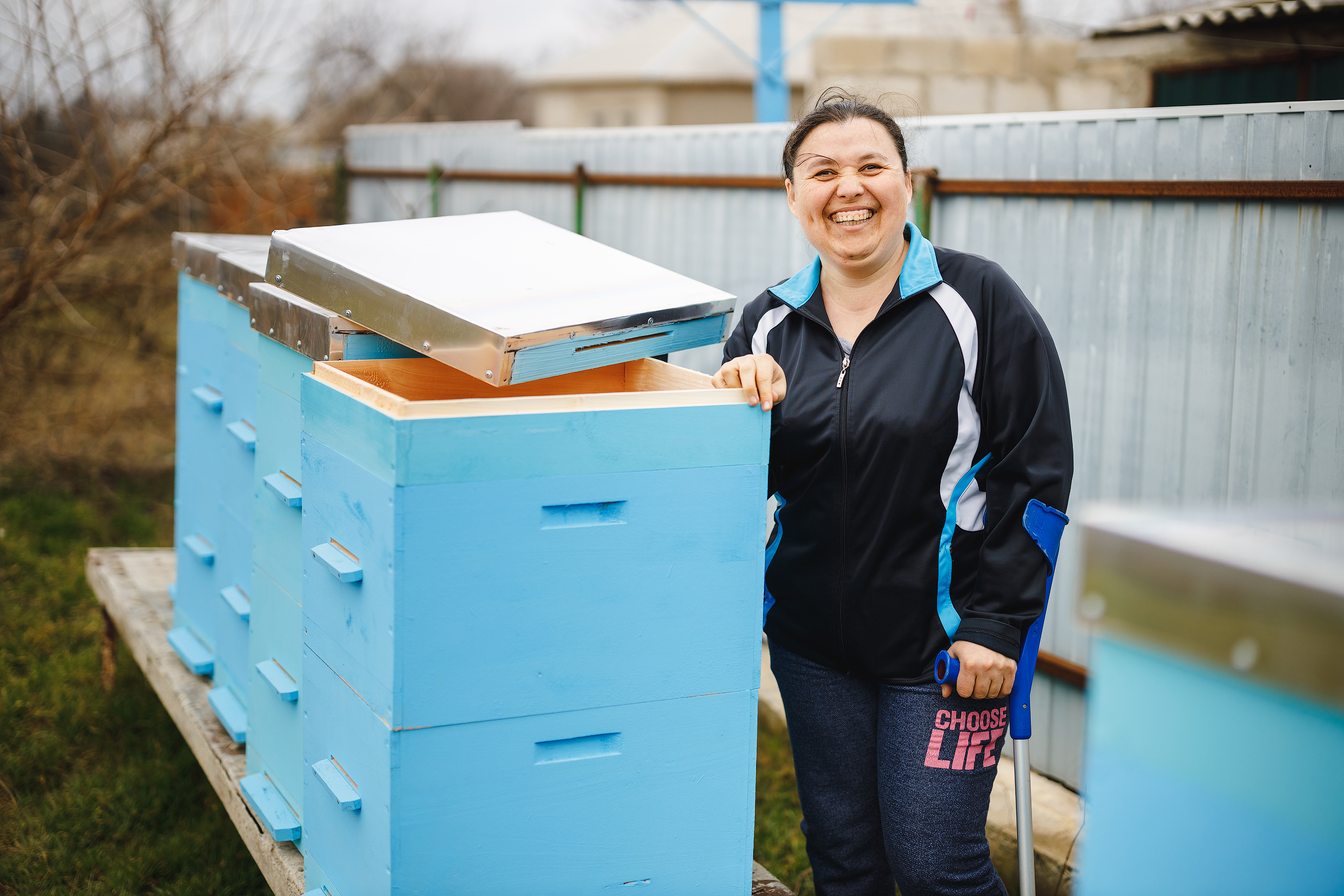 Viorica se apoya en una muleta junto a sus colmenas. 