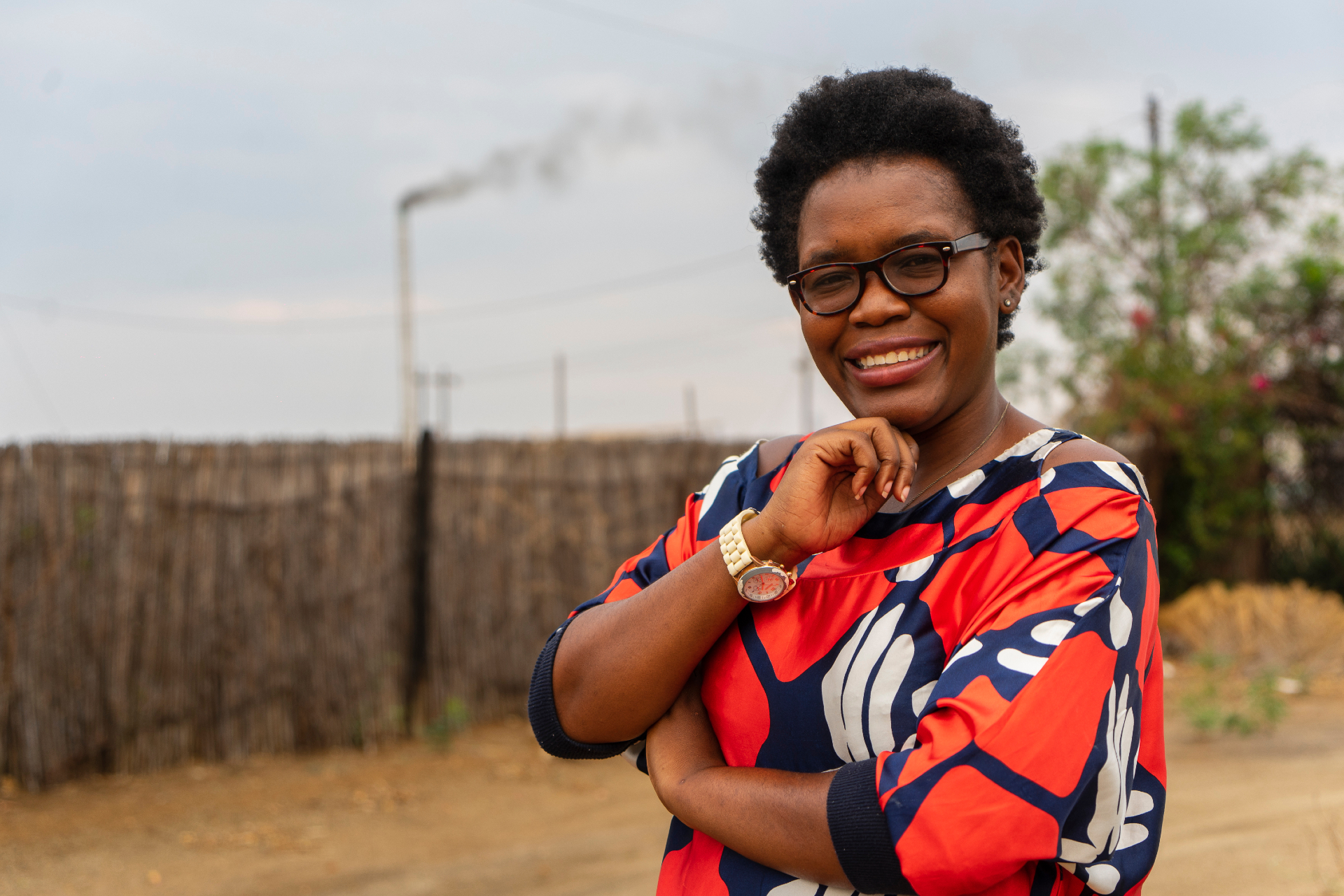 Portrait of Mendy Lerato Lusaba in bright orange, blue and white shirt.
