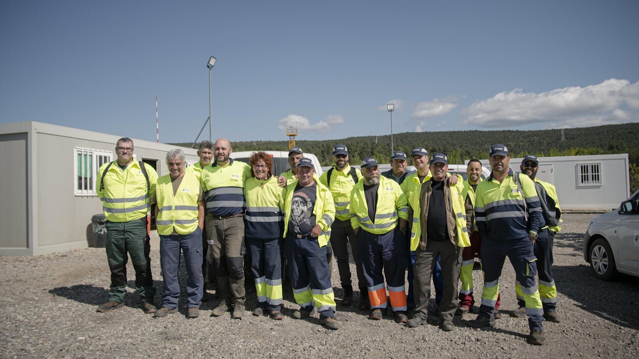 Cristina Carro and other quarry truck drivers stand together and smile for the camera. 