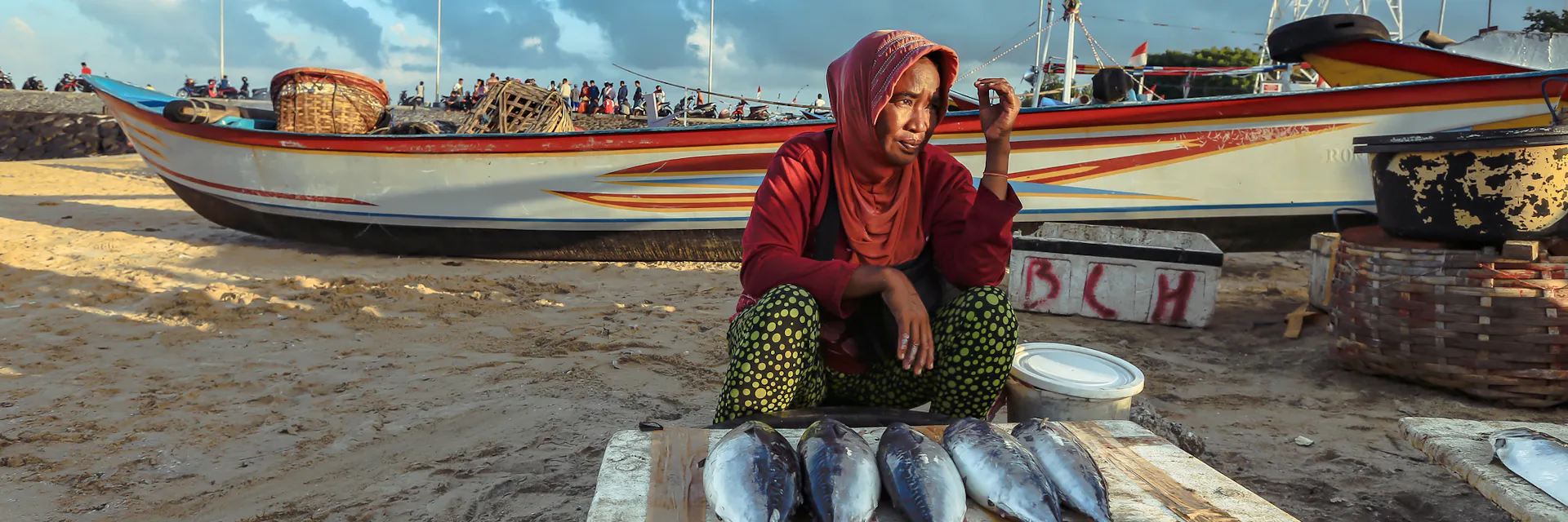 Balinese fishmonger woman sells fish in the morning market in Kedonganan - Passer Ikan, Jimbaran beach in Bali, Indonesia.