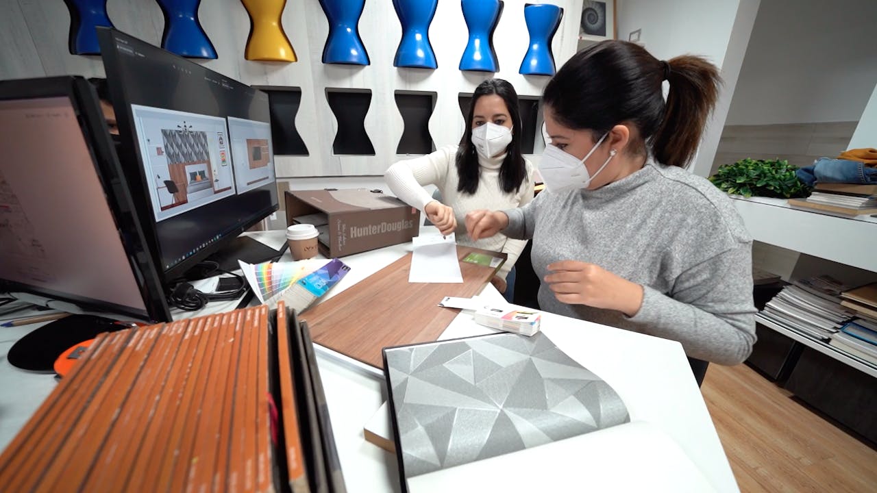 Women architects work in an office with face masks. 