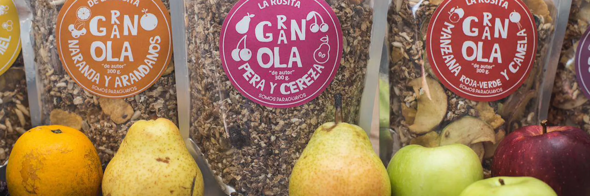 Bolsas de granola hechas por Rossana Migliore están sobre una mesa junto con frutas
