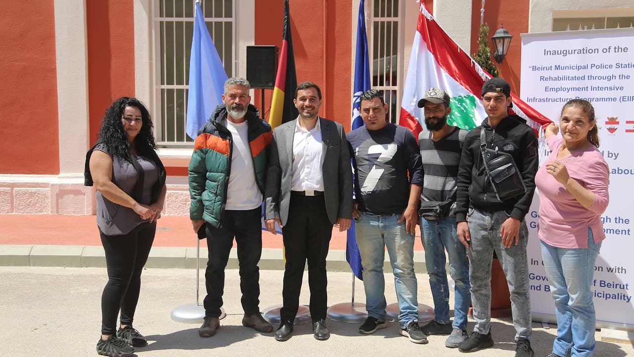 Some of the workers and contractor stand in front of the rehabilitated municipal police building. 