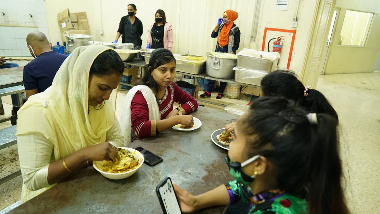 Maya Aktar déjeune avec d’autres jeunes travailleuses migrantes dans une cantine.