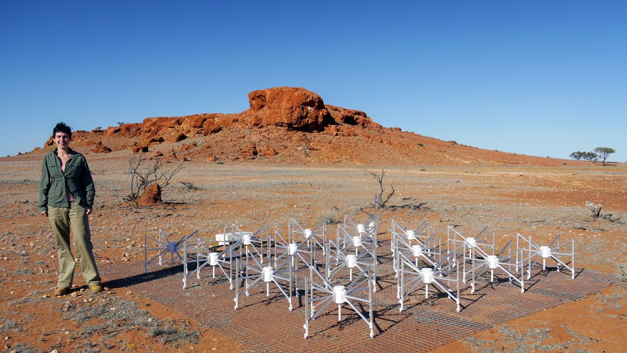 Dr Natasha Hurley-Walker stands next to one of the 256 tiles of the Murchison Widefield Array (MWA) telescope, which was used to detect the mysterious radio source.